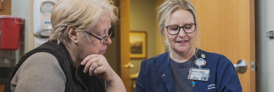 A patient navigator speaking to a cancer patient.