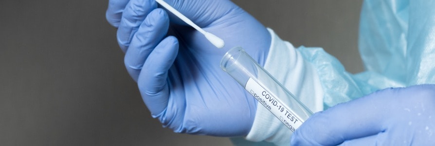 Healthcare worker holding a COVID-19 test swab