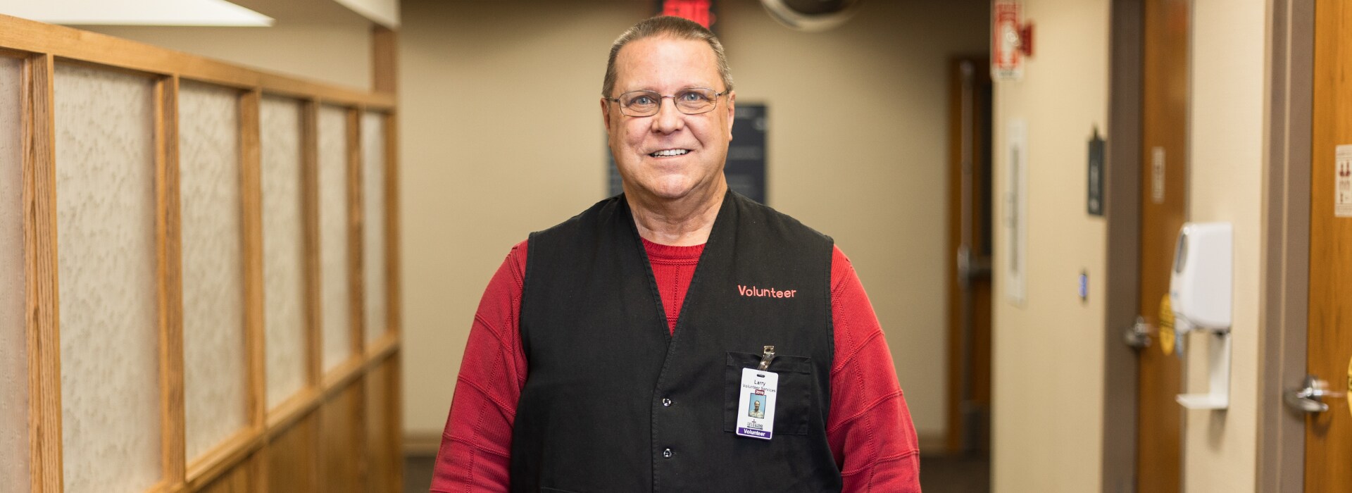 Volunteer sits at welcome desk to greet guests