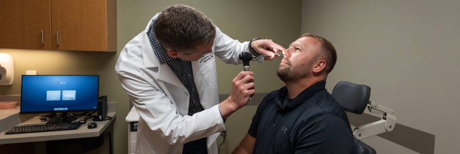 ENT provider with patient examining their nose