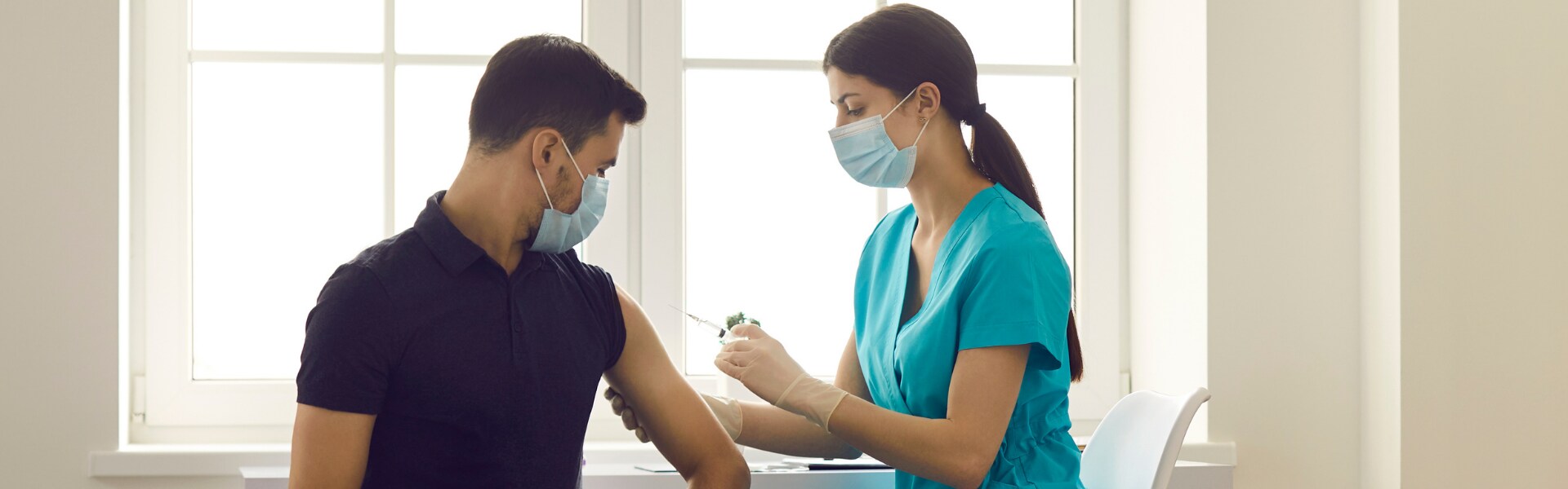 A person receiving a vaccine by a nurse.