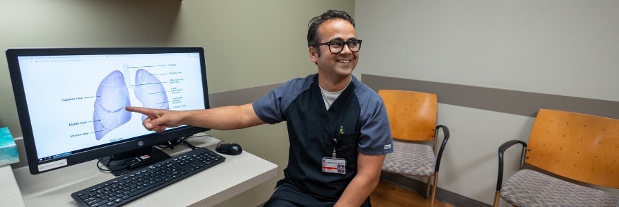 Dr. Nepal, a pulmonologist, showing a patient a pair of lungs.