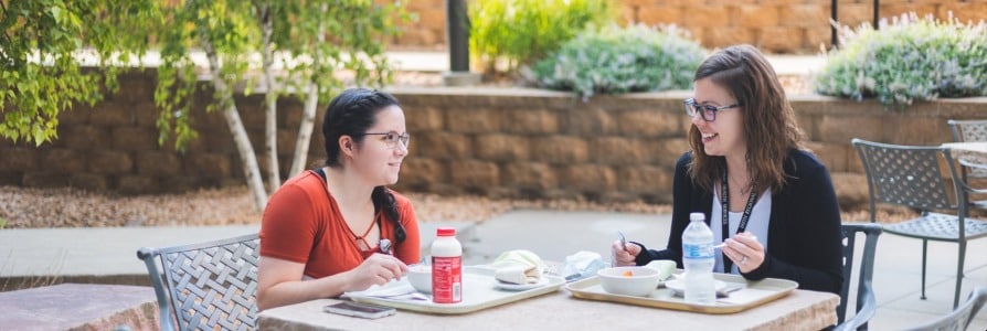 Two Faith Regional employees sitting outside eating lunch