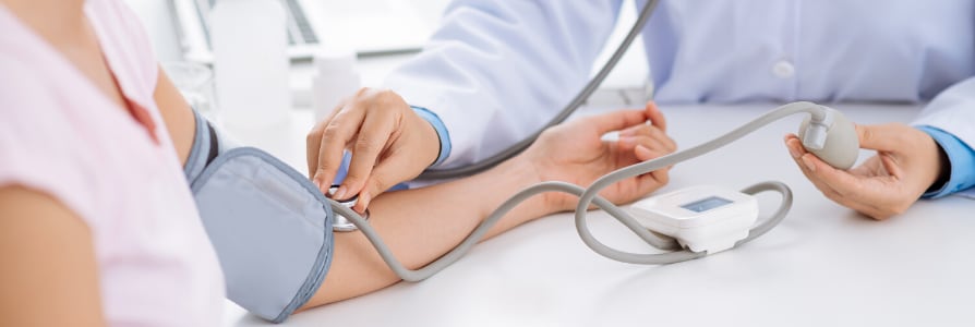 Doctor checking a patient blood pressure.