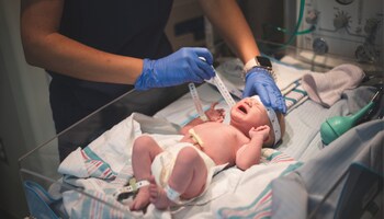 A newborn being measured by a Faith Regional nurse.