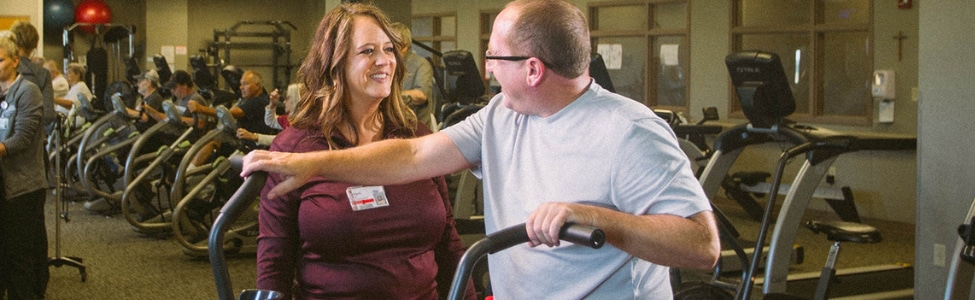 A nurse in cardiac rehab monitoring a patient.