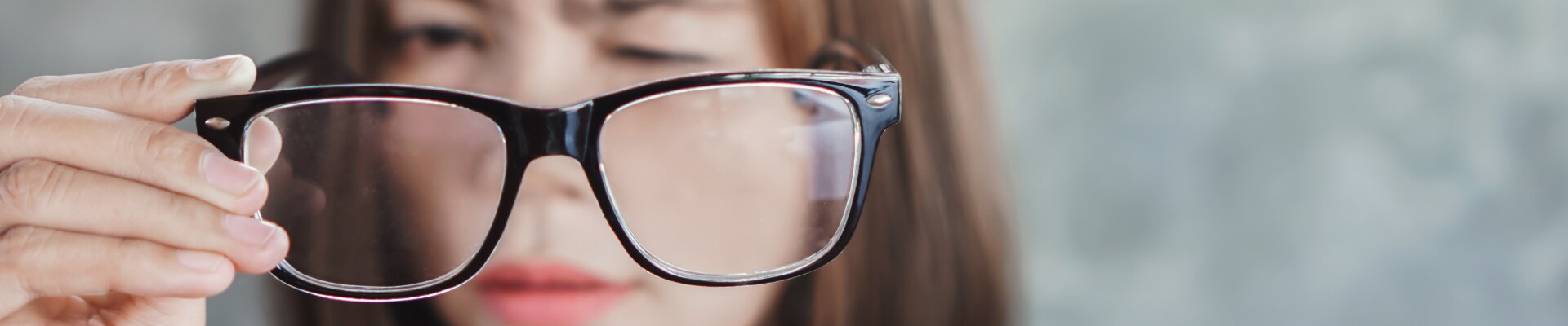 woman with blurred vision looking through glasses