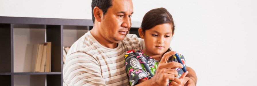 Father helping daughter check blood sugar.