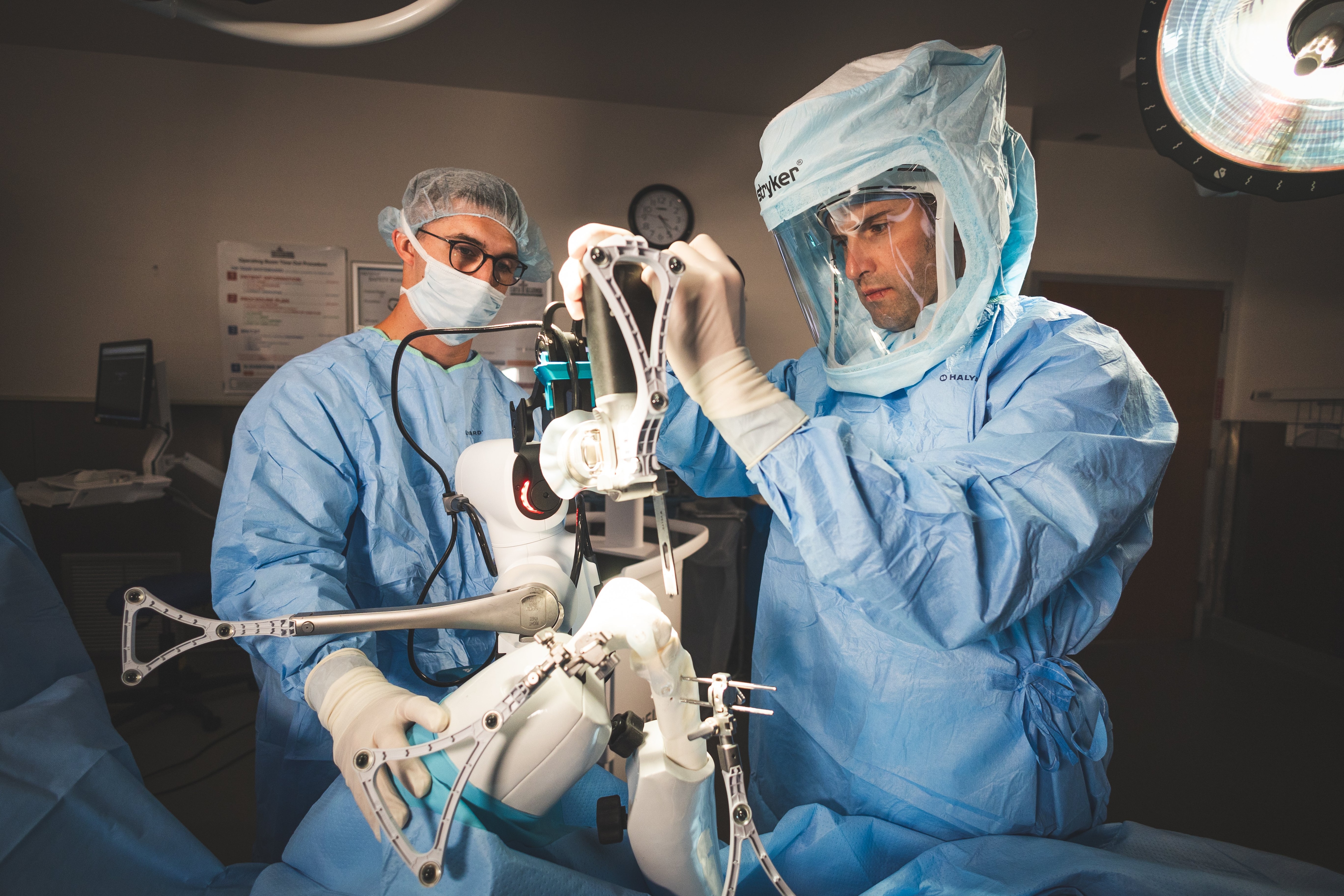 Orthopedic surgeons performing a knee surgery using robot-assisted technology.