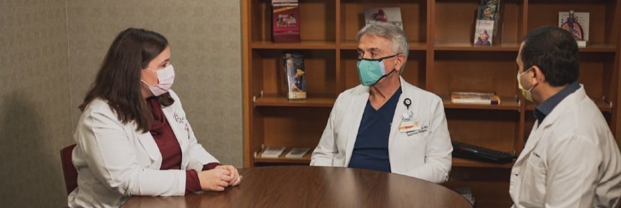 Cancer oncology medical staff meeting around a table