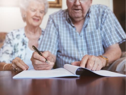 An elderly couple filling out their will.