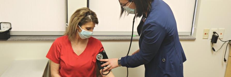 An occupational medicine nurse performing an employee health screening.