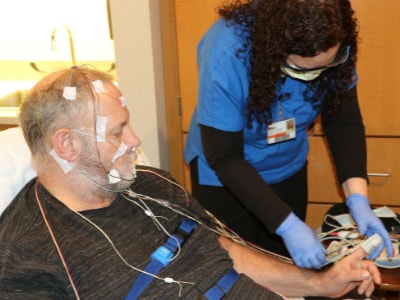 A sleep technologist preparing a patient for his sleep study.